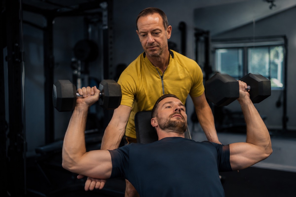 Jim spotting a male client during incline dumbbell training at Core Values PT, Bournemouth